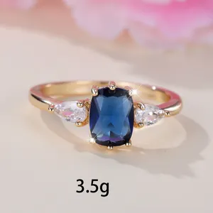 Bague de luxe en or avec saphir bleu rectangulaire et pierres latérales en goutte
