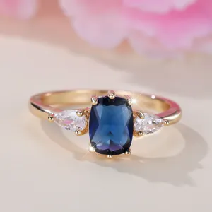 Bague trois pierres avec saphir bleu taille coussin et gemmes latérales poires en or