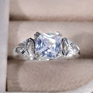 Elegant silver square cut zircon ring with side stones on a beige jewelry box