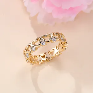 Close-up of gold hollow heart ring featuring sparkling inlaid zircon stones for women