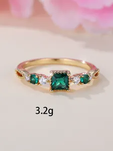 Macro-opname van 18K gouden ring met vierkante smaragd en gegraveerde details