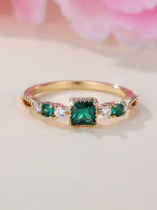 Macro-opname van vierkante smaragden ring met zij-filigraan en pavé gezette diamanten