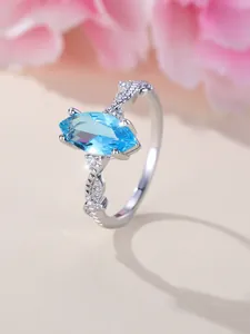 Detailed macro view of marquise cut blue gemstone on an intricate twisted silver band