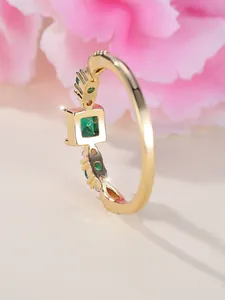 Detail van vierkante smaragd met pavé-diamanten op goud vergulde kruisring