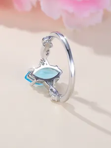 Macro shot of silver ring featuring marquise-cut blue gem and intricate hollow craftsmanship