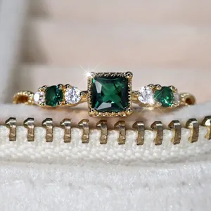 Luxe goudkleurige ring met vierkante smaragdgroene steen en kristallen accenten
