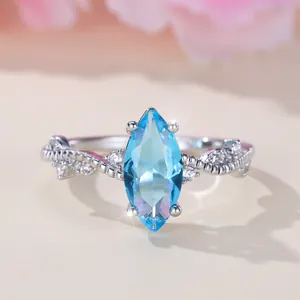 Elegant marquise-cut sky blue gemstone ring with twisted diamond band in silver