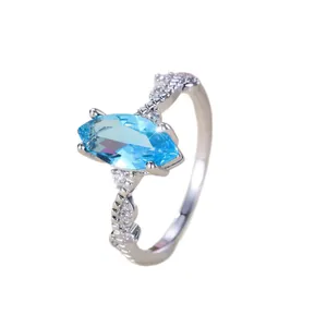 Minimalist marquise cut light blue gemstone ring with criss-cross pavé silver band