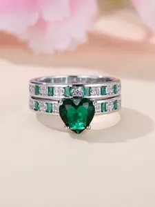 Detail view of heart-shaped emerald stone ring set with silver-plated band