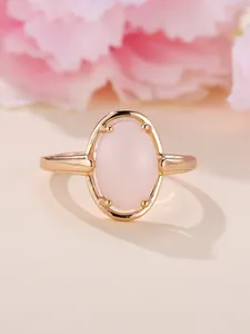 Nahaufnahme eines champagnergoldenen Rings mit großem ovalen rosa Edelstein in 4-Krallen