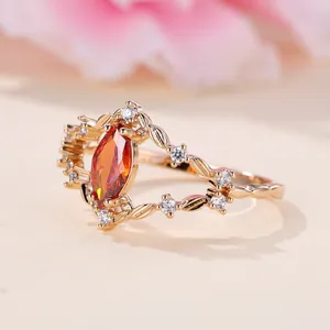 Ring in Champagnergold mit marquise-rotem Stein und blattförmigem Reben-Design