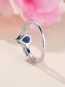 Dettaglio della pietra preziosa blu scuro a cuore con incisioni decorative ad ala