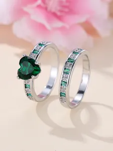 Detail shot of heart emerald ring set with white gold finish and baguette side stones