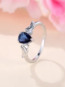 Vista macro di un anello ali di pipistrello con una pietra blu a forma di cuore