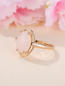 Detail eines champagnergoldenen Rings mit großem ovalem rosa Edelstein in Vier-Krallen-Fassung