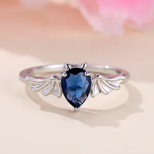 Anello alla moda con gemma blu a goccia e accenti di ali di pipistrello argento
