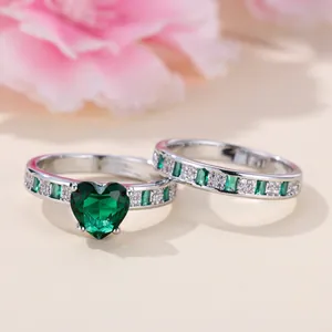 Elegant heart-shaped emerald ring set with micro-paved silver bands in a gift display