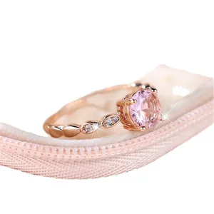 Elegant rose gold ring with a round pink gemstone on a soft velvet ring box