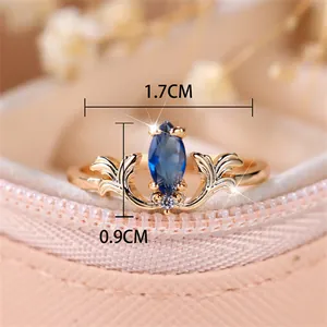 Vintage gold ring with marquise blue gemstone and delicate leaf-shaped engravings