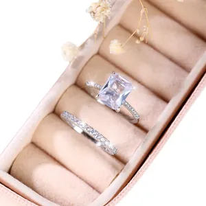 Elegante zilverkleurige ringenset met emerald geslepen zirkoon op beige fluweel