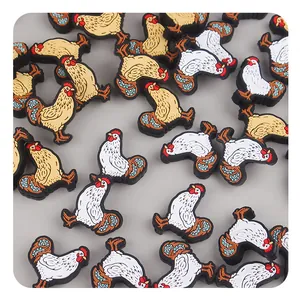 Detailed close-up of cartoon rooster charms in white and yellow for DIY baby accessories