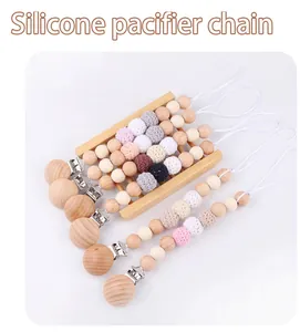 Dettaglio di catenelle per ciuccio in legno e silicone su un espositore minimalista