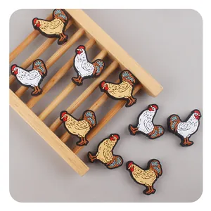 Detailed view of colorful PVC rooster charms with textured 3D details for DIY accessories