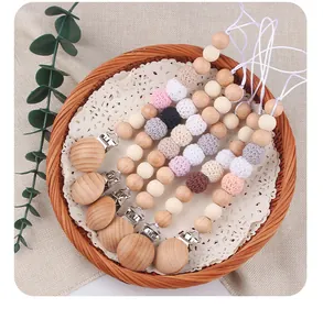 Dettaglio di 5 catenelle portaciuccio fatte a mano in legno di faggio e cotone crochet