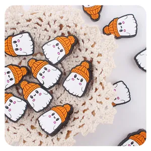 Detalle de lindos dijes de fantasma de PVC con sombreros naranjas para accesorios DIY