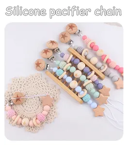 Close-up of silicone pacifier clips with beech wood star pendants in pastel colors