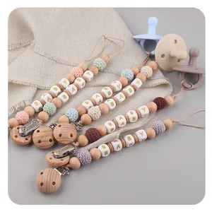 Detail of wooden pacifier clips with colorful crochet beads and baby letter accents