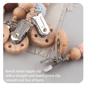 Detail of beech wood pacifier clip with colorful woven balls and secure metal fastener