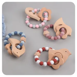 Detail of bird and elephant beech wood teethers with Morandi silicone beads for babies
