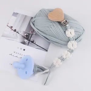 Handmade woven daisy pacifier clip with silicone soother and wooden heart-shaped clamp