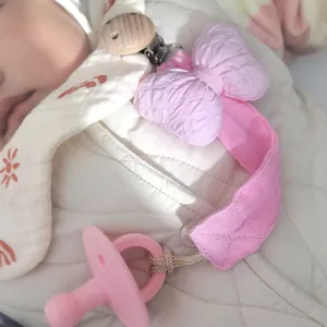 Rosa Silikon Schnuller Set mit Clip aus Buchenholz und Baumwollschleife auf Jacke