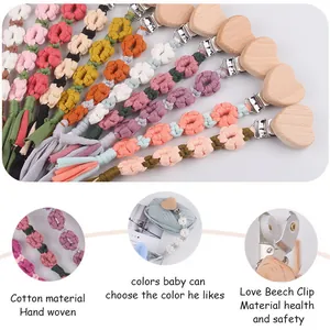 Detail of hand-woven cotton pacifier clip with heart-shaped beech wood fastener
