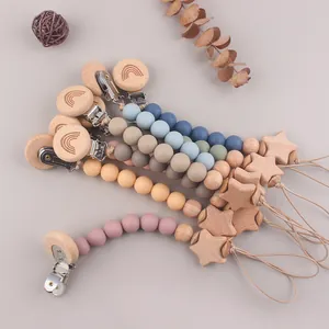 Beech wood pacifier clips with silicone beads and engraved rainbow stars in a fan display