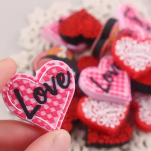 Close-up of heart-shaped Love charms and checkered PVC accessories for DIY jewelry