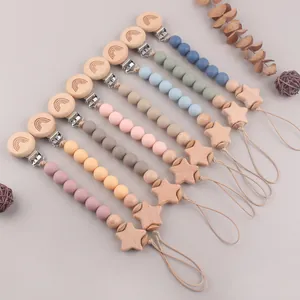 Close-up of beech wood pacifier clip with silicone beads and engraved rainbow star detail