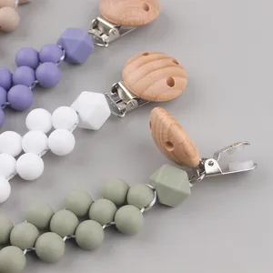 Handmade beech wood and silicone baby pacifier clips in Morandi green, purple, and white