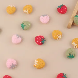 Detailed view of colorful strawberry silicone beads for DIY pacifier clips and teethers