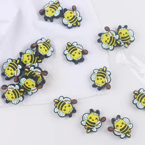 Close-up of DIY silicone cartoon bee charms for baby pacifier clips and teething crafts