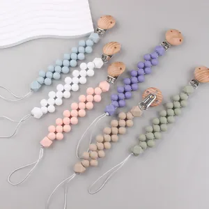 Close-up of colorful silicone beads and beech wood clips on baby pacifier chains