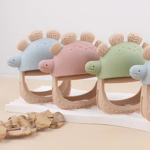 Anneau de dentition dinosaure en silicone pour bébé sur un support blanc élégant