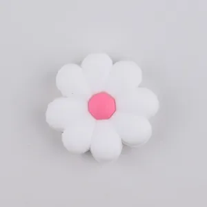 Detail view of a white silicone daisy bead with a pink center for DIY jewelry making