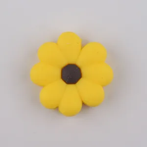 Macro detail of food-grade silicone daisy bead with yellow petals and brown center