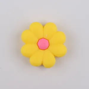 Macro shot of yellow silicone daisy flower bead with pink center for DIY jewelry and shoes