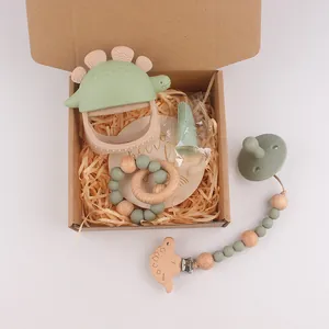Detail van baby bijtring set met siliconen dinosaurus en houten clip in geschenkdoos