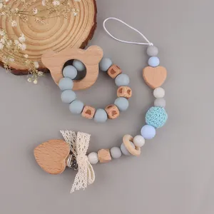 Detail of wooden bear teether set with food-grade silicone beads and pacifier clip
