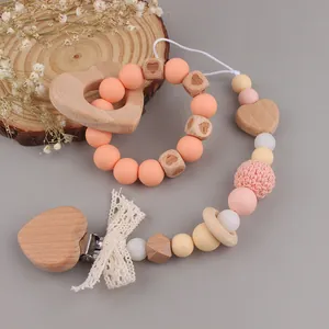 Detail of beech wood baby teether ring and pacifier clip with lace and silicone beads